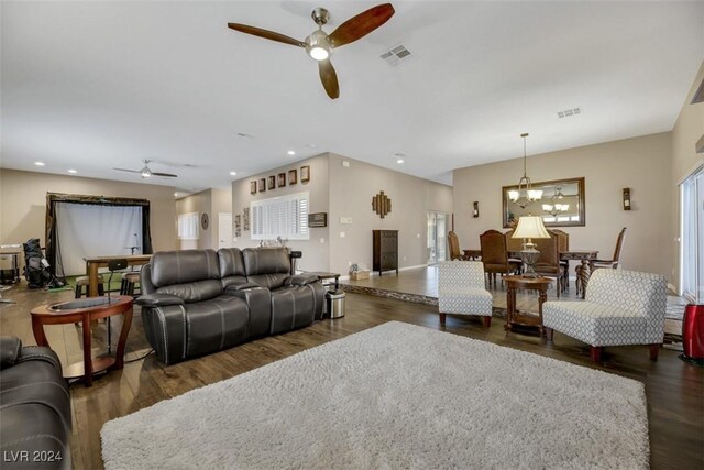 living room with dark hardwood / wood-style floors and ceiling fan with notable chandelier