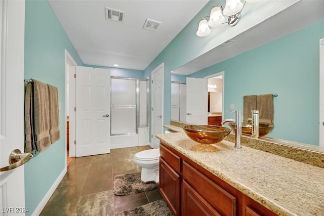 bathroom featuring vanity, an enclosed shower, and toilet