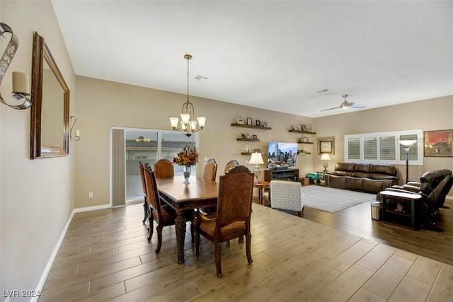 dining area with ceiling fan with notable chandelier