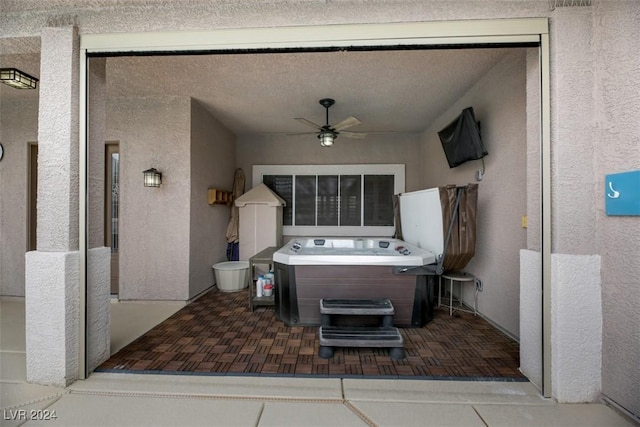 view of patio / terrace with ceiling fan and a hot tub