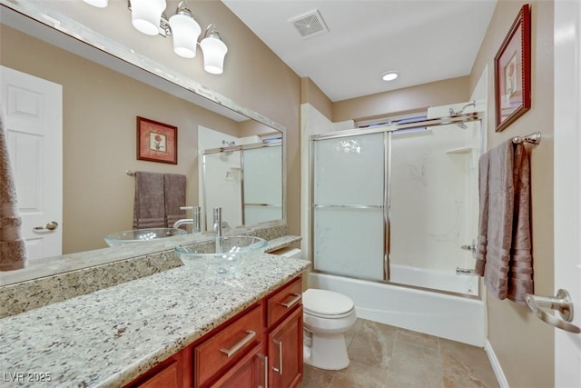 bathroom featuring vanity, baseboards, visible vents, bath / shower combo with glass door, and toilet