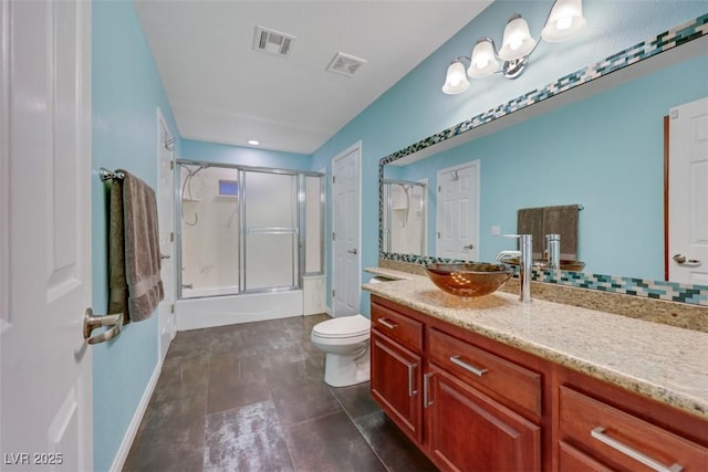 bathroom featuring visible vents, enclosed tub / shower combo, toilet, and vanity