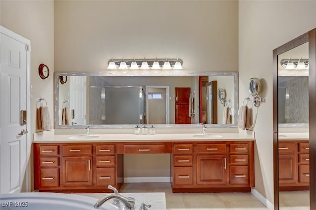 full bath featuring double vanity, a stall shower, tile patterned floors, and a sink