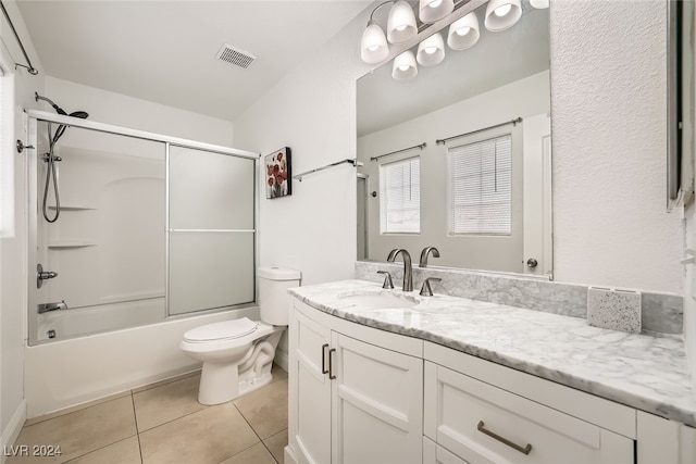 full bathroom featuring tile patterned flooring, vanity, combined bath / shower with glass door, and toilet