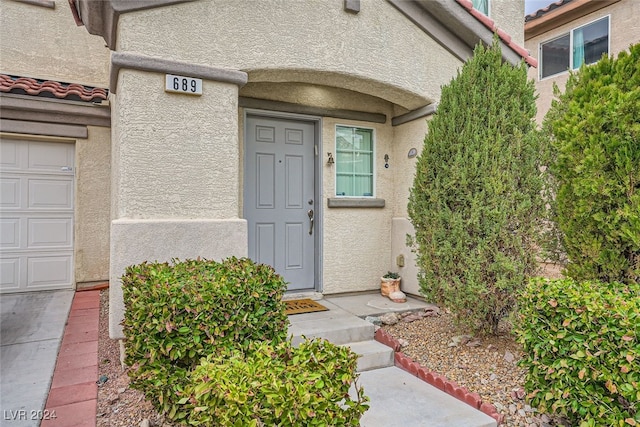 doorway to property with a garage