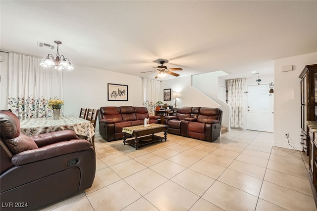 tiled living room with ceiling fan with notable chandelier