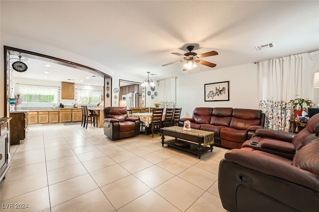 living room with ceiling fan with notable chandelier and light tile patterned flooring