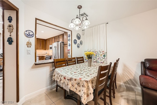 tiled dining space featuring an inviting chandelier