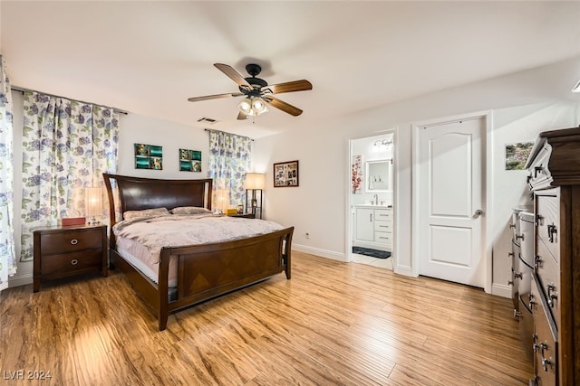 bedroom featuring ensuite bathroom, light hardwood / wood-style floors, sink, and ceiling fan