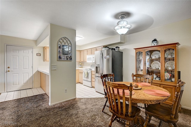 dining space with light carpet, a textured ceiling, and ceiling fan