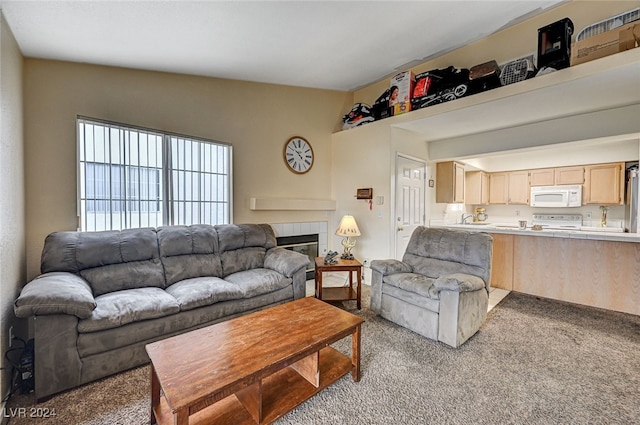 carpeted living room with a tiled fireplace and vaulted ceiling