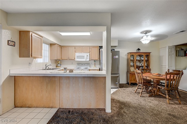 kitchen featuring white appliances, sink, light brown cabinets, light tile patterned floors, and tile countertops