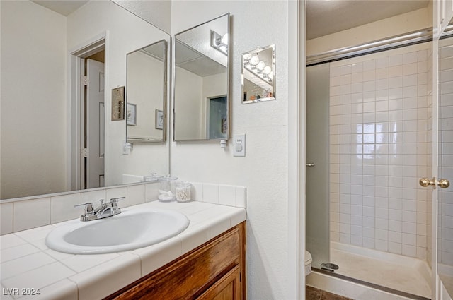 bathroom with an enclosed shower, vanity, and toilet