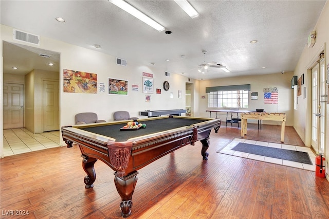 playroom featuring ceiling fan, light wood-type flooring, a textured ceiling, and billiards