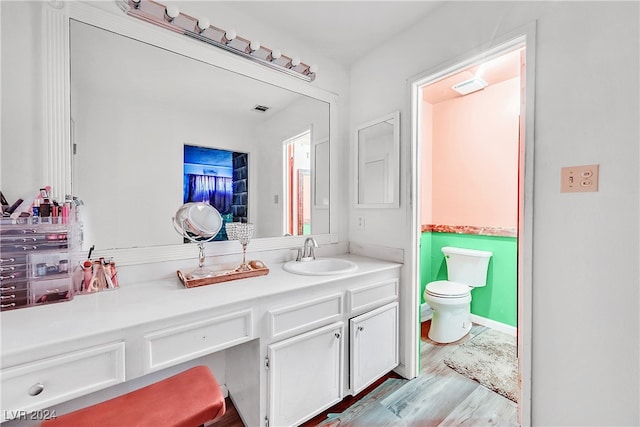 bathroom with hardwood / wood-style flooring, vanity, and toilet