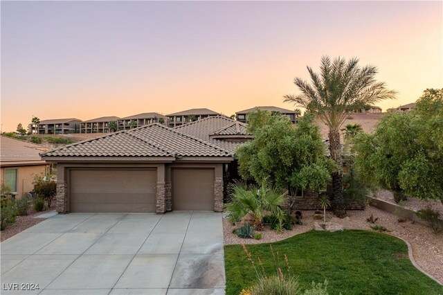 view of front of property featuring a yard and a garage