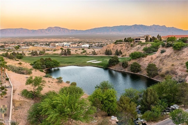 aerial view at dusk featuring a water and mountain view