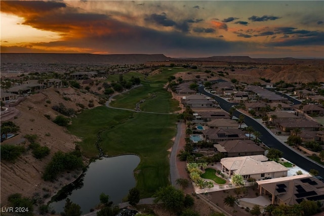 aerial view at dusk featuring a water view