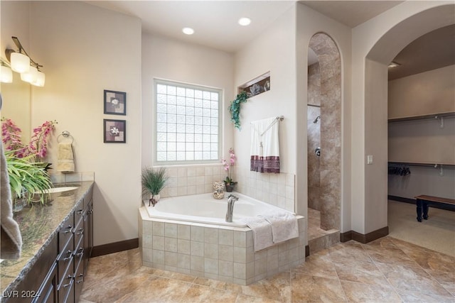 bathroom with shower with separate bathtub and vanity