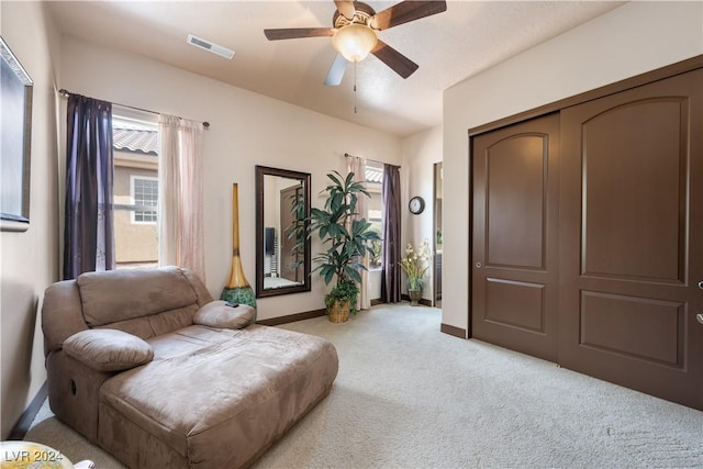 sitting room featuring light colored carpet and ceiling fan