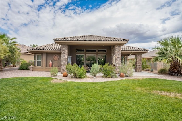 rear view of property featuring a lawn