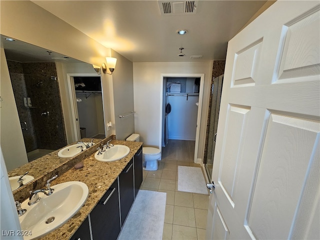 bathroom with tile patterned floors, vanity, walk in shower, and toilet