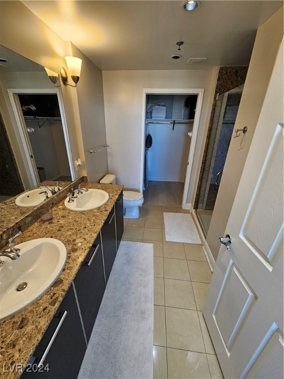 bathroom with toilet, vanity, tile patterned floors, and an enclosed shower