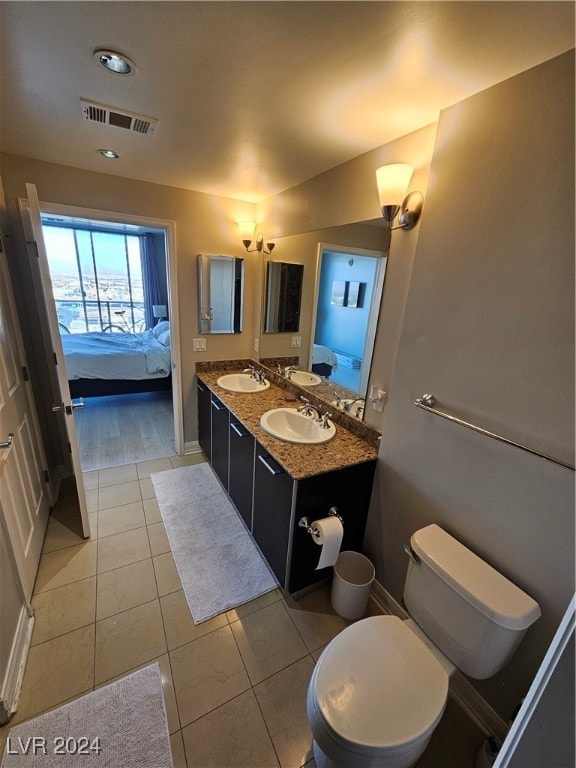 bathroom featuring toilet, vanity, and tile patterned floors