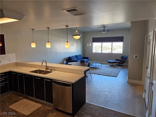 kitchen with kitchen peninsula, dark hardwood / wood-style floors, stainless steel dishwasher, and sink