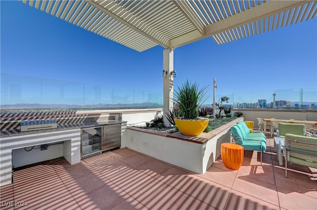 view of patio / terrace with a pergola, wine cooler, and an outdoor kitchen