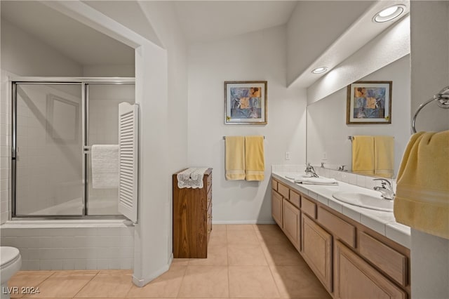 bathroom with vanity, vaulted ceiling, tile patterned flooring, toilet, and an enclosed shower