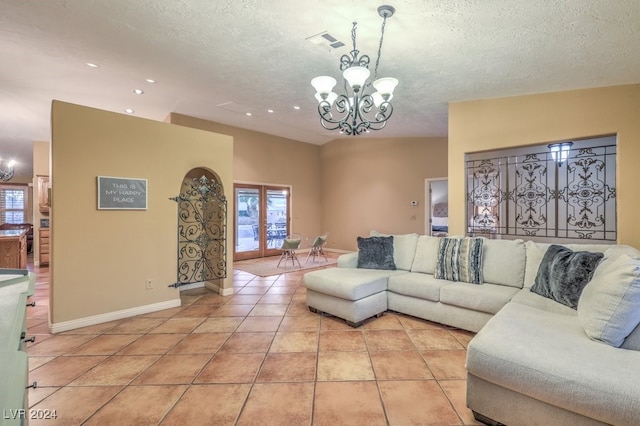 living room featuring light tile patterned floors, a chandelier, and a textured ceiling