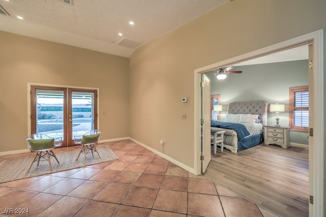 foyer with light tile patterned floors, a textured ceiling, ceiling fan, and french doors