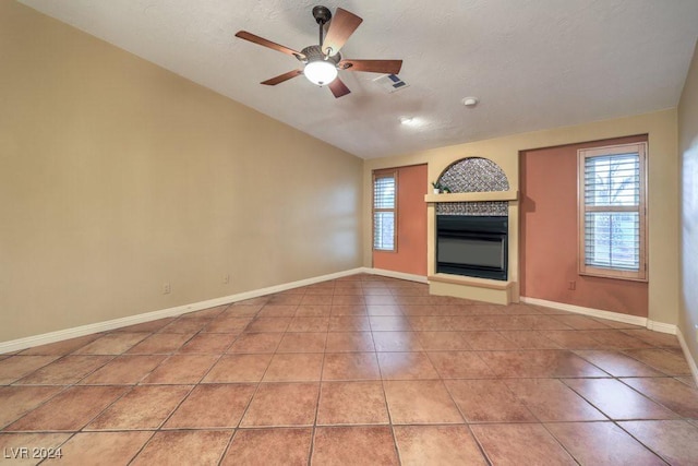 unfurnished living room featuring vaulted ceiling, tile patterned floors, and ceiling fan