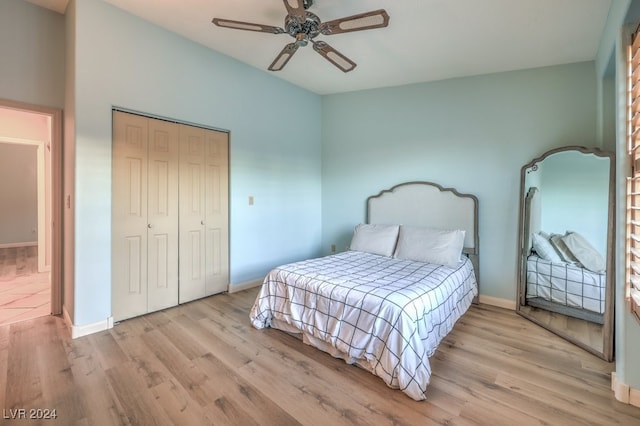 bedroom with light wood-type flooring, ceiling fan, and a closet