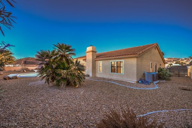 back of house featuring central AC unit and a fenced in pool