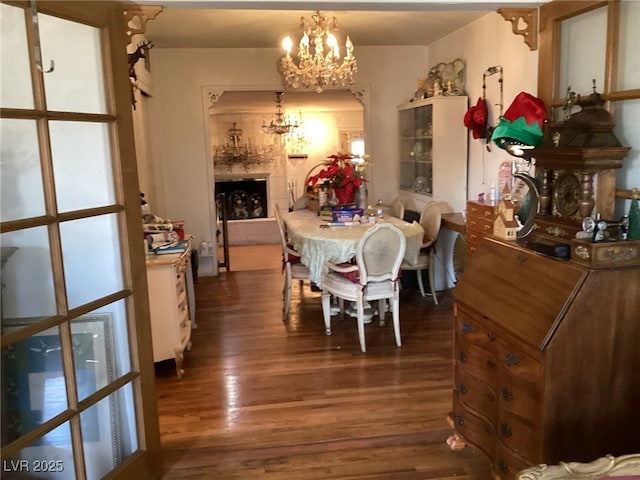 dining area with dark hardwood / wood-style floors and a notable chandelier