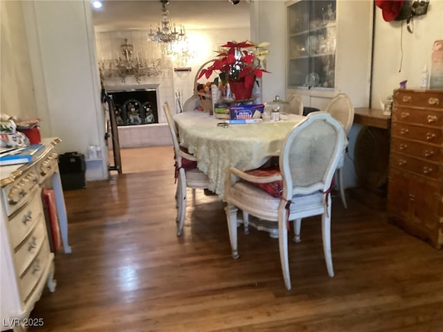 dining area with dark wood-type flooring and a notable chandelier