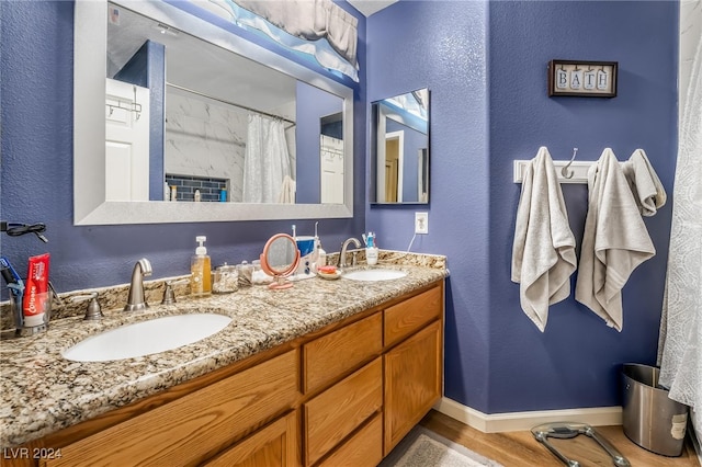 bathroom with hardwood / wood-style floors, vanity, and walk in shower