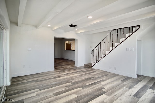 unfurnished living room with beamed ceiling and hardwood / wood-style floors