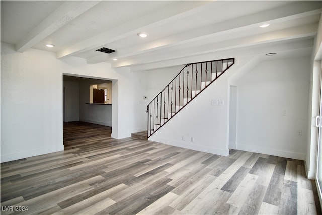 unfurnished room featuring beamed ceiling and hardwood / wood-style floors