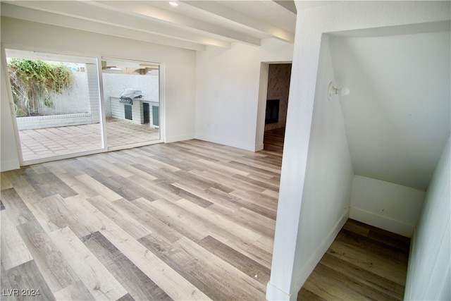 interior space featuring beam ceiling and light hardwood / wood-style flooring