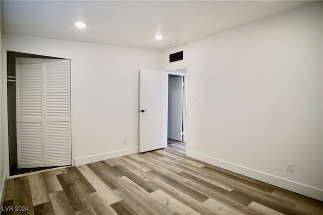 unfurnished bedroom with light hardwood / wood-style floors and a closet