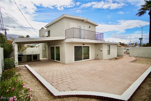 back of property with a patio area, a balcony, and exterior kitchen