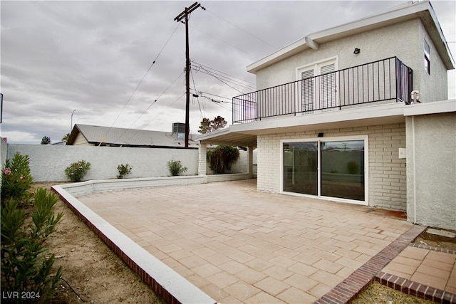 rear view of house with a patio area and a balcony