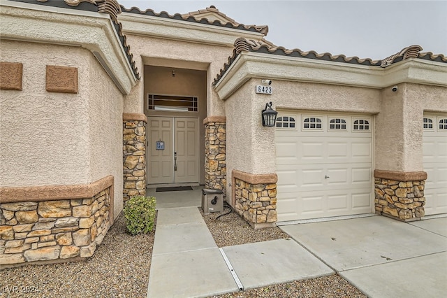 doorway to property with a garage