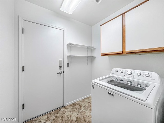 washroom featuring washer / dryer and cabinet space