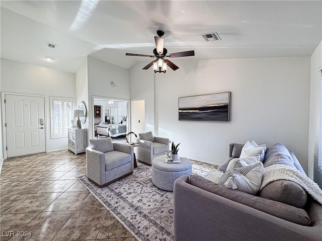 tiled living room featuring lofted ceiling, ceiling fan, visible vents, and baseboards