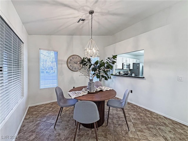 dining area featuring baseboards, visible vents, and a chandelier