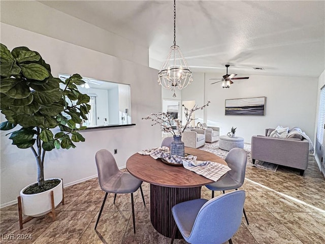 dining space with vaulted ceiling, ceiling fan with notable chandelier, visible vents, and baseboards